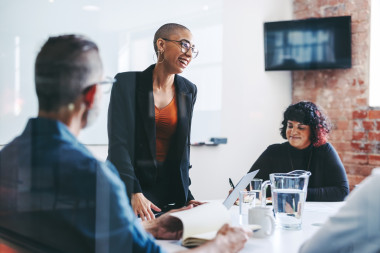 Colleague standing and speaking in meeting